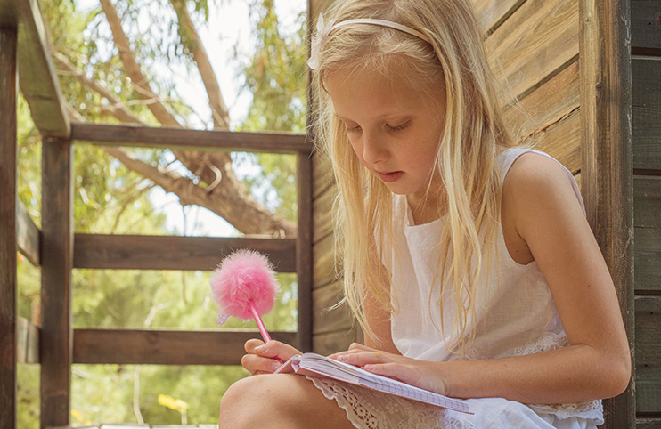 Blond Girl writing in the notebook