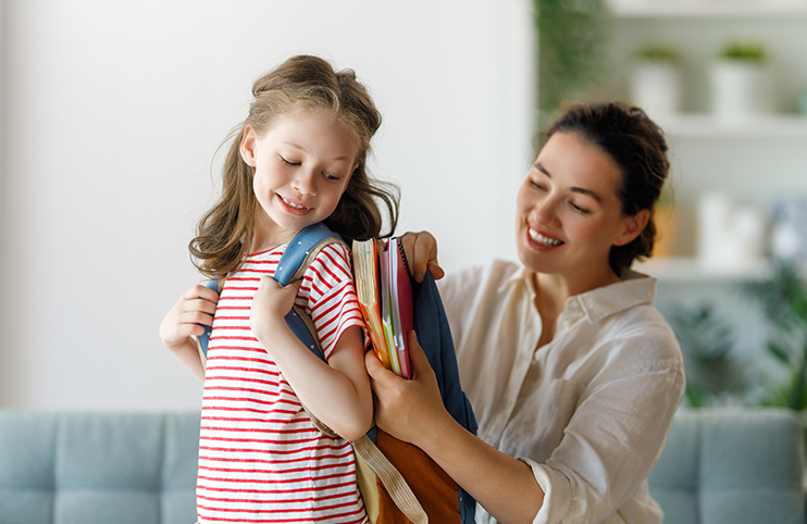 Happy family preparing for school. Little girl with mother.